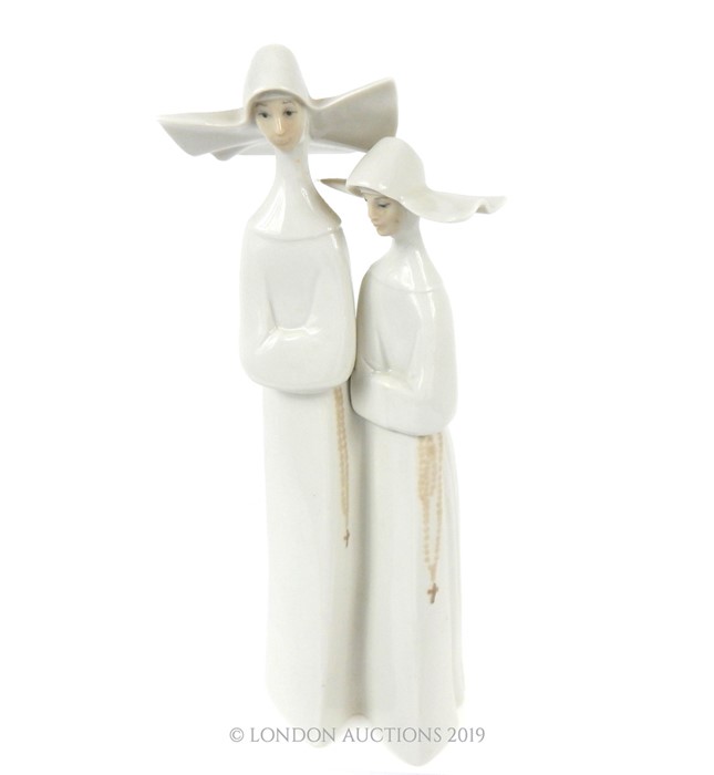 A LLadro Ceramic Statuette Depicting A Pair Of Nuns.