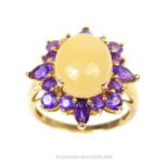 A 14 Carat Gold Oval Claw Cabochon White Jade with Halo of Amethyst Ring.