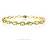 A 9 Carat Gold Nineteen Oval Cut Peridot Tennis Bracelet.