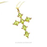 An Oval Cut Peridots And Diamond Cross Pendant.