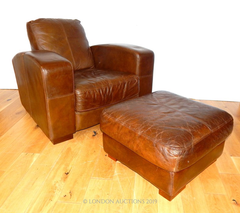 A Leather Armchair And Footstall