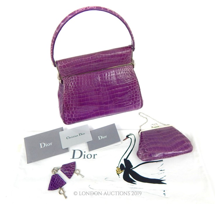 A Purple Crocodile Skin Christian Dior Handbag With Matching Clutch