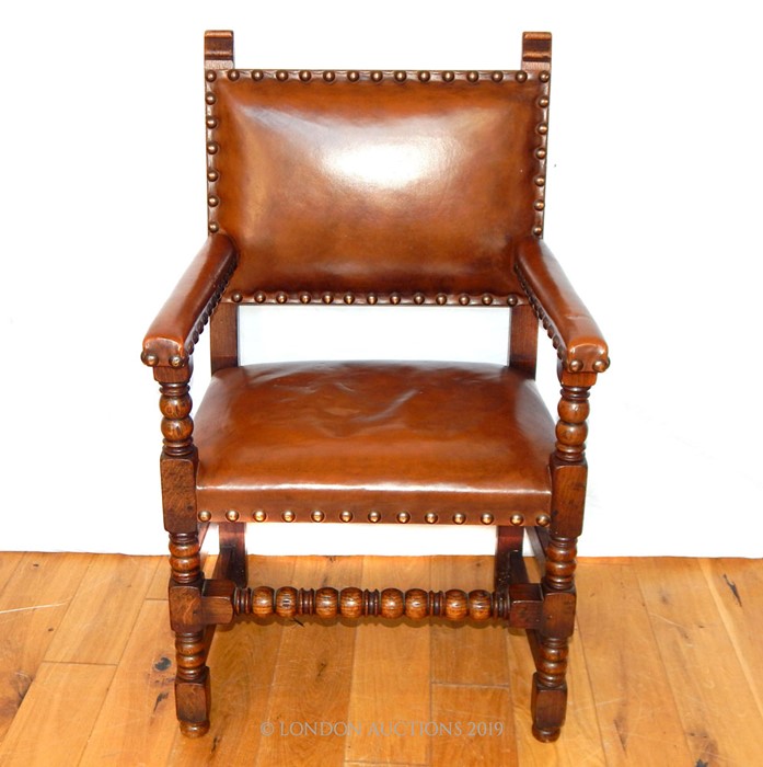 A 17th Century Style Leather Upholstered Elm Arm Chair.