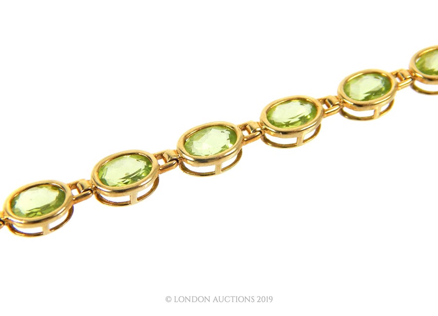 A 9 carat Gold Tennis Bracelet set with nineteen oval cut Peridot. - Image 2 of 3