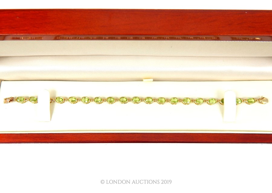 A 9 carat Gold Tennis Bracelet set with nineteen oval cut Peridot. - Image 3 of 3