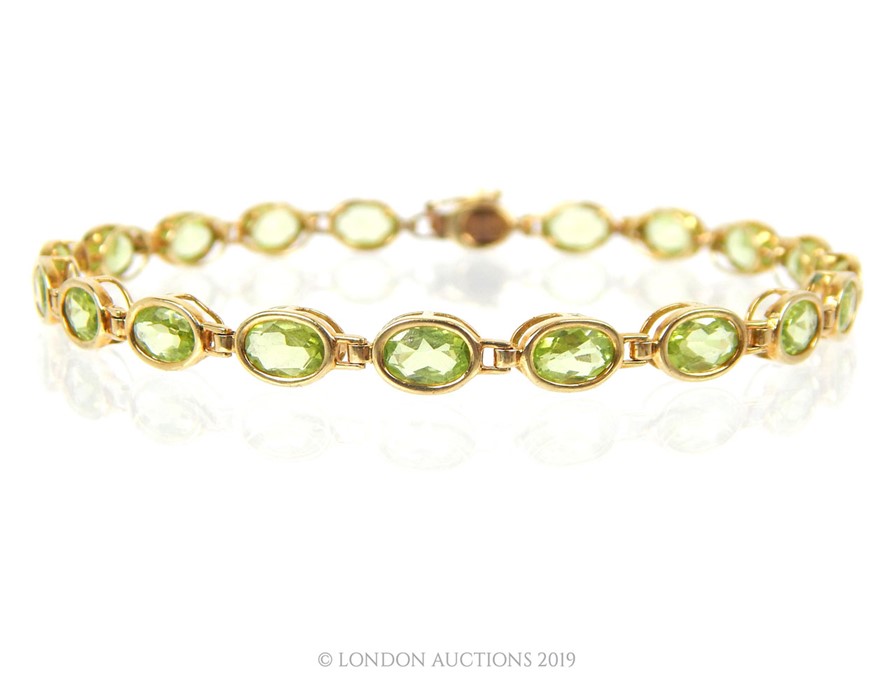 A 9 carat Gold Tennis Bracelet set with nineteen oval cut Peridot.