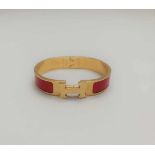 HERMES PARISBRACELET Clic H en métal doré et laque rouge, PM, poignée .Approx. 15,5 cm.