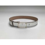 GUCCI- MADE IN TALYCeinture en cuir argenté et métal doré.. Signé. T.80.Long. totale: 90 cm .En l'