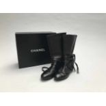 CHANELPAIRE DE BOTTES en cuir d'agneau noir à surpiqûres blanches. T.36,5 cm. Signé. Boîte d'