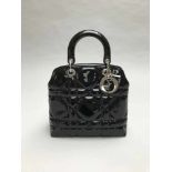 CHRISTIAN DIORSAC LADY DIOR en cuir noir verni .Garniture et logo en métal argenté. Poignées rigides