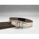 GUCCI- MADE IN TALYCeinture en cuir argenté et métal doré. Elastique au dos. Signé. T.75. Dans sa