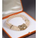 COLLIER EN OR serti de trois rangs de perles de culture, souligné de barrettes en or jaune