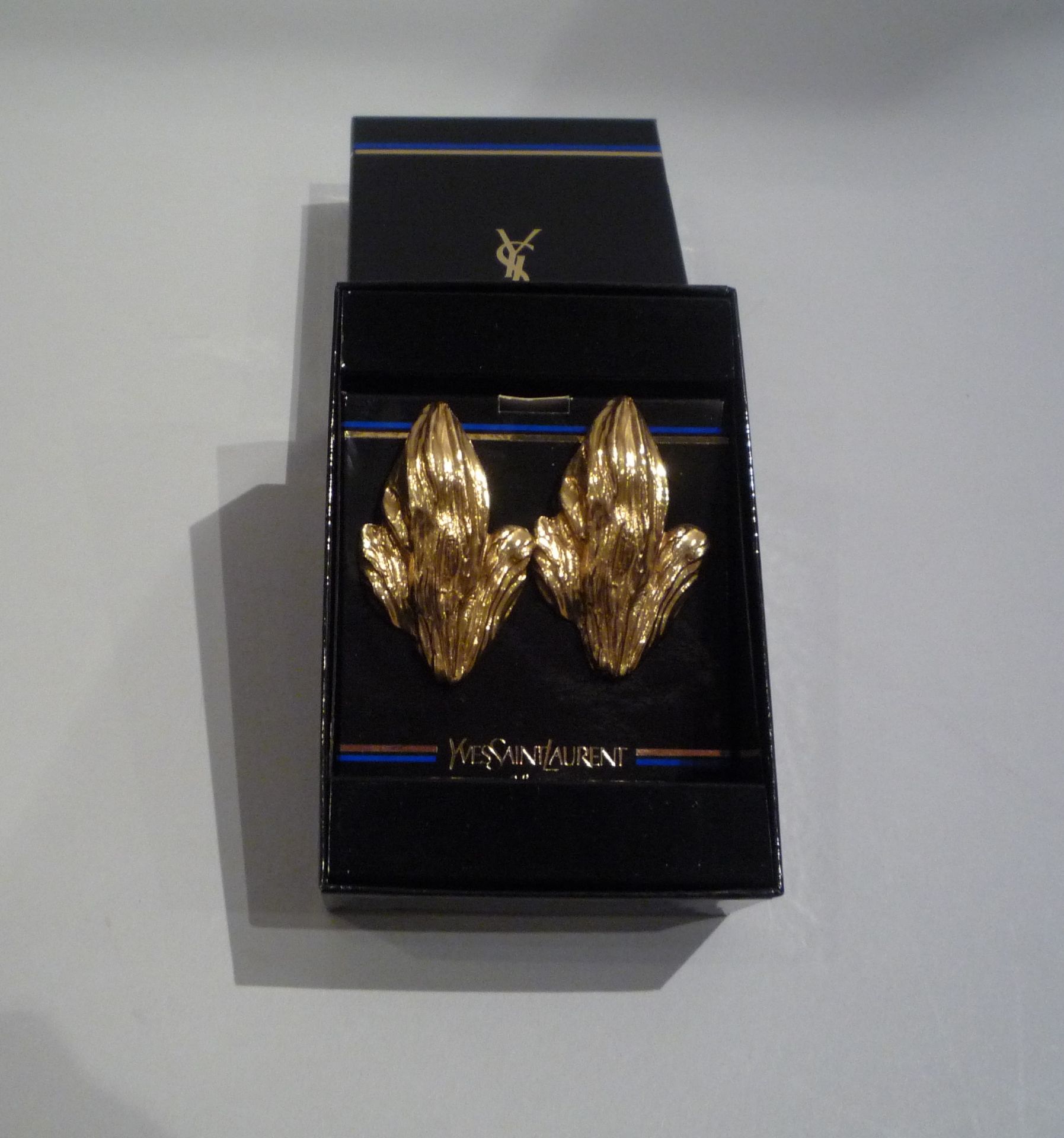 YVES SAINT LAURENT - PAIRE DE BOUCLES D'OREILLE en forme de feuille en métal doré. [...]