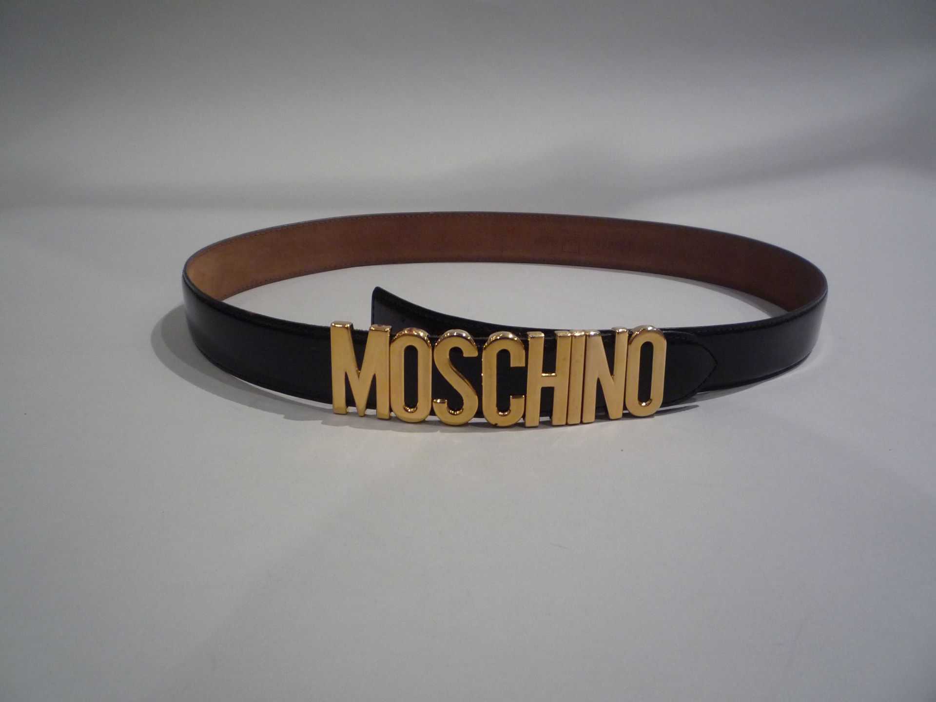 MOSCHINO - Made in Italy - CEINTURE en cuir noir. Boucle en méta doré. T.52. Long. [...]