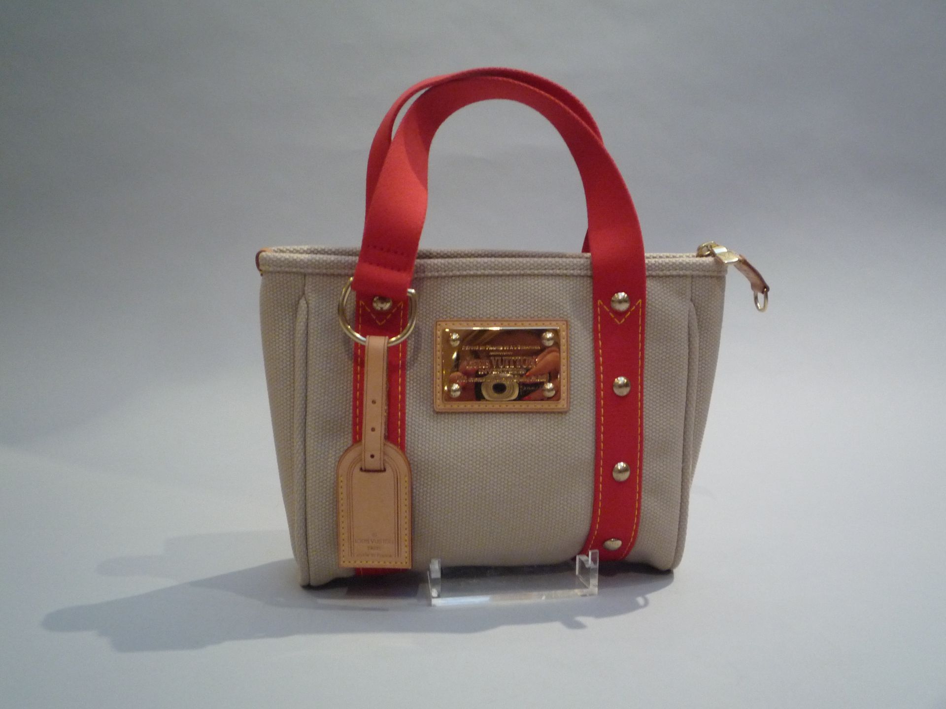 LOUIS VUITTON - PETIT SAC en cuir, toile beige et rouge. Signé. - Excellent état. [...]