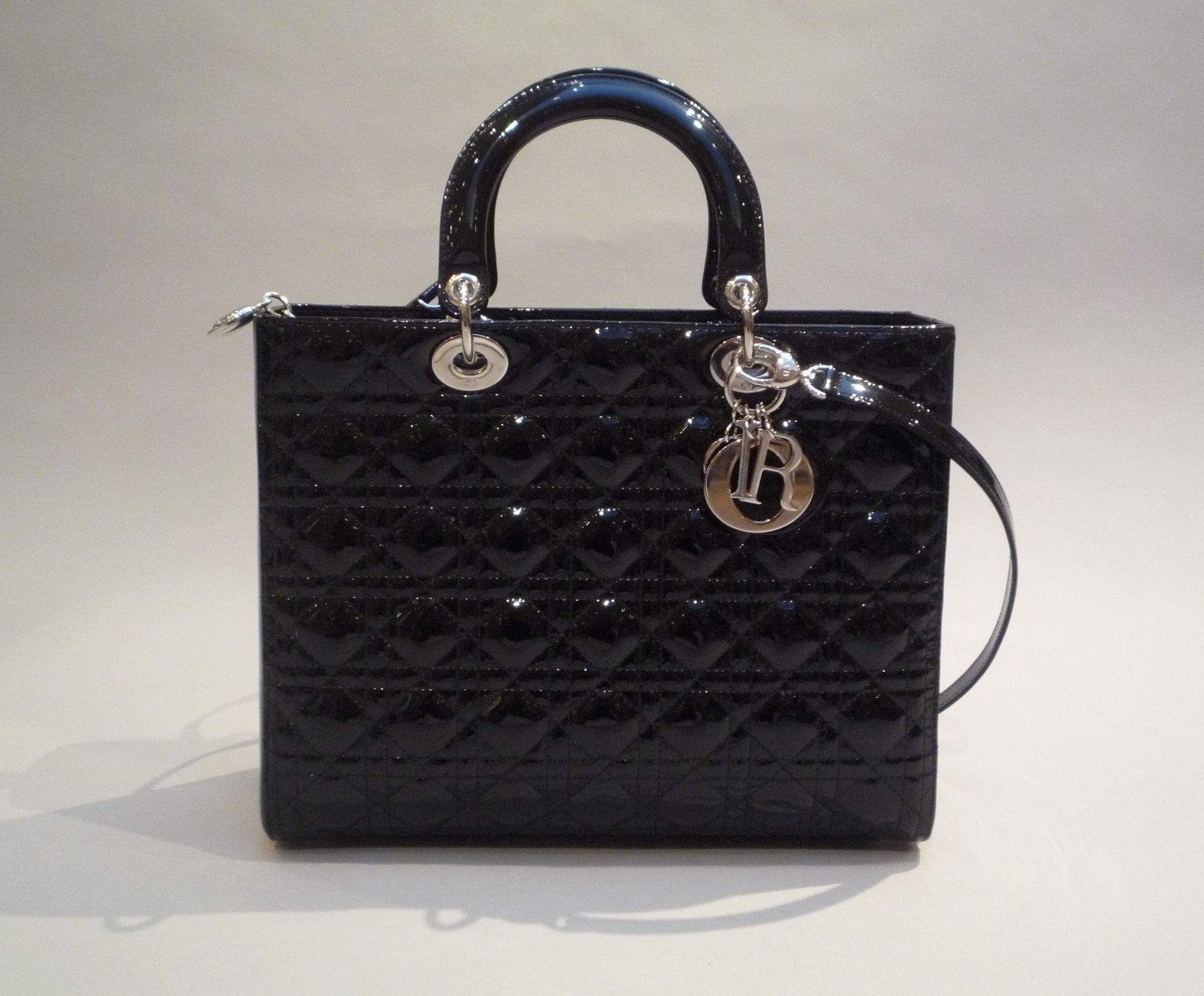 CHRISTIAN DIOR - SAC LADY DIOR en cuir verni noir. Garniture en métal argenté [...]