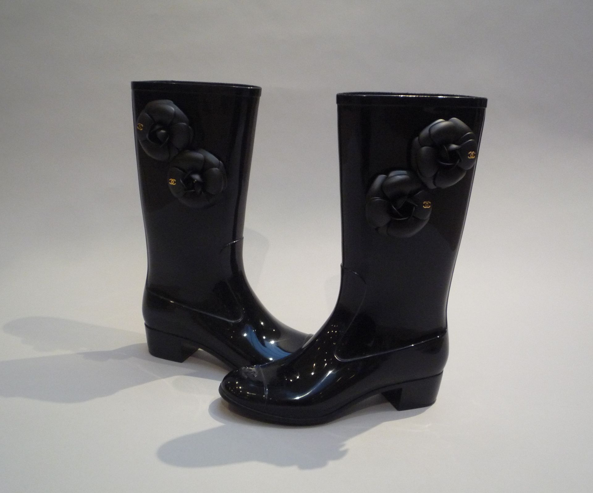 CHANEL - PAIRE DE BOTTES en caoutchouc noir à motif de fleurs camélia. T.37. [...]