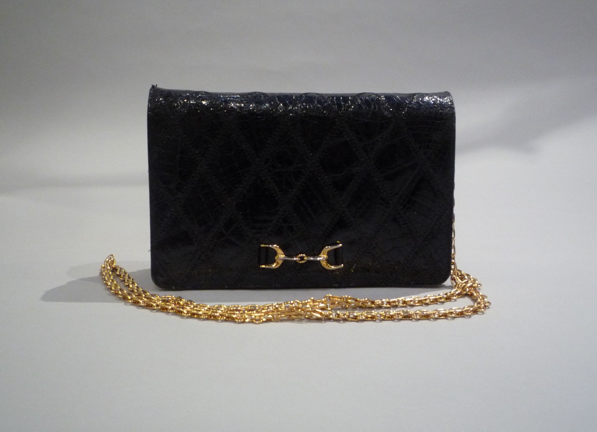 PETIT SAC DE SOIREE en cuir et crocodile surpiqué. Chaînette et fermoir en métal [...]