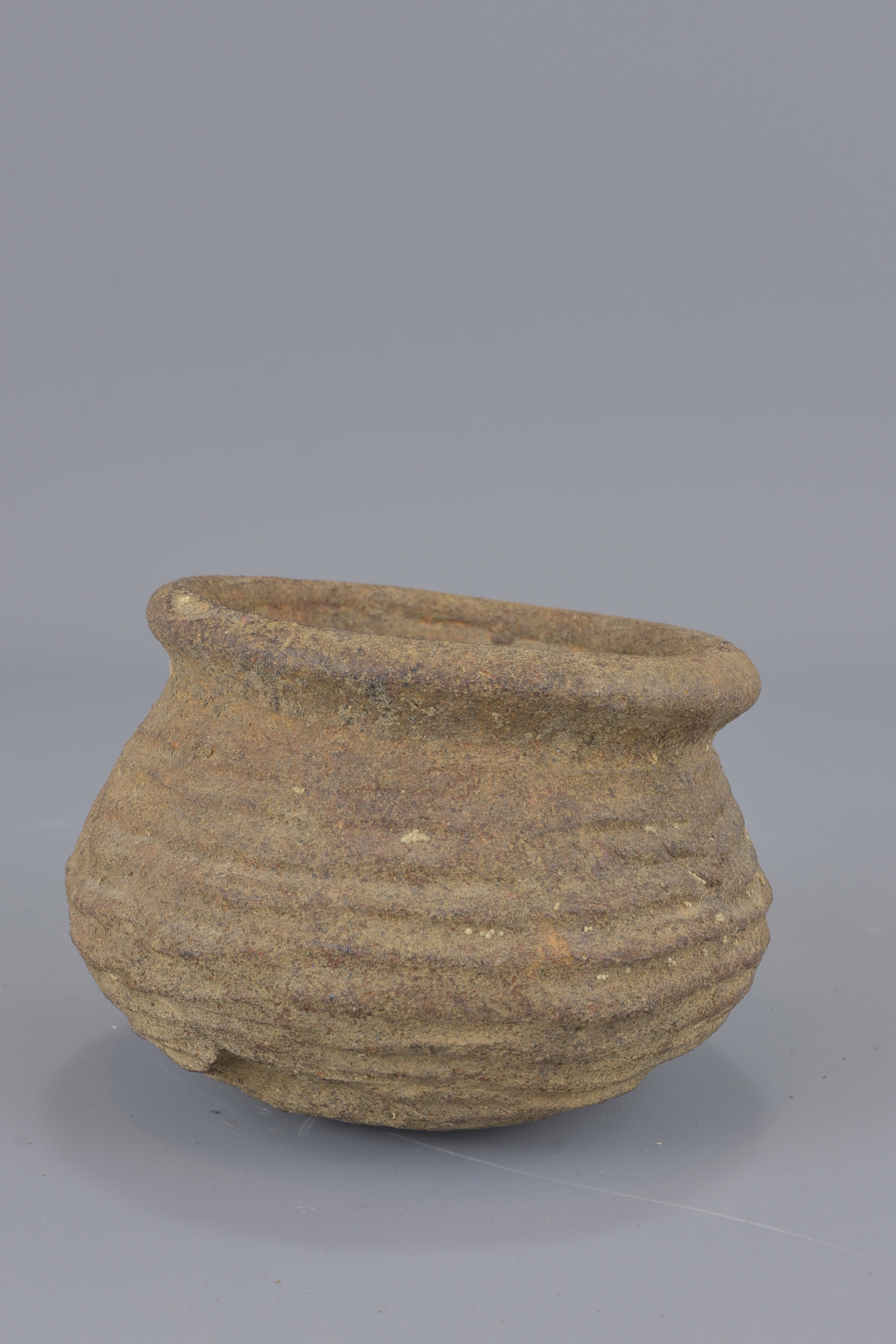 A stoneware Neolithic pot. 8cm tall