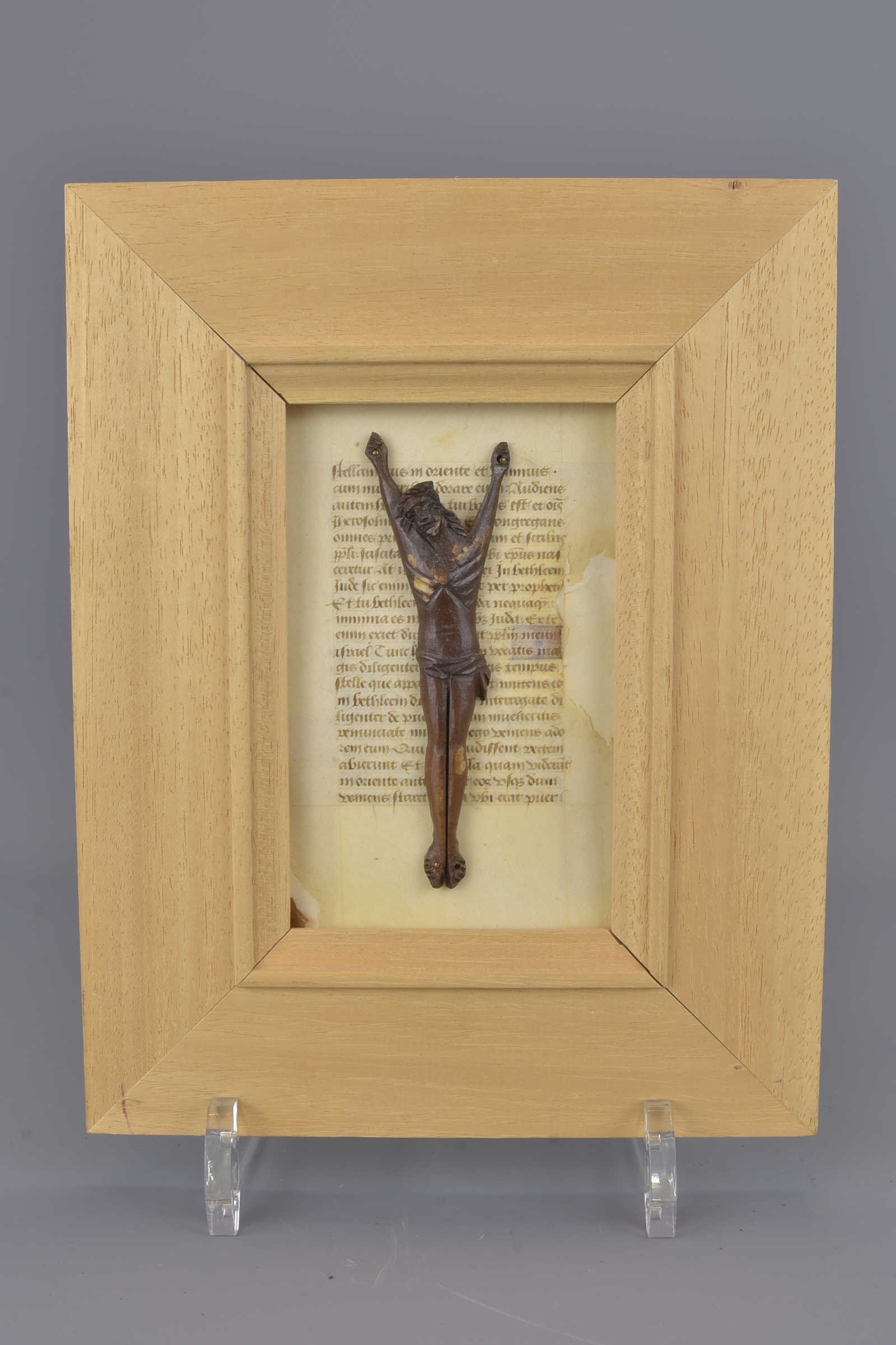 A bone crucifix carving on paper manuscript page.