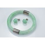 A jadeite bangle with silver mounts together with