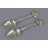 A pair of South East Asian mask head silver spoons