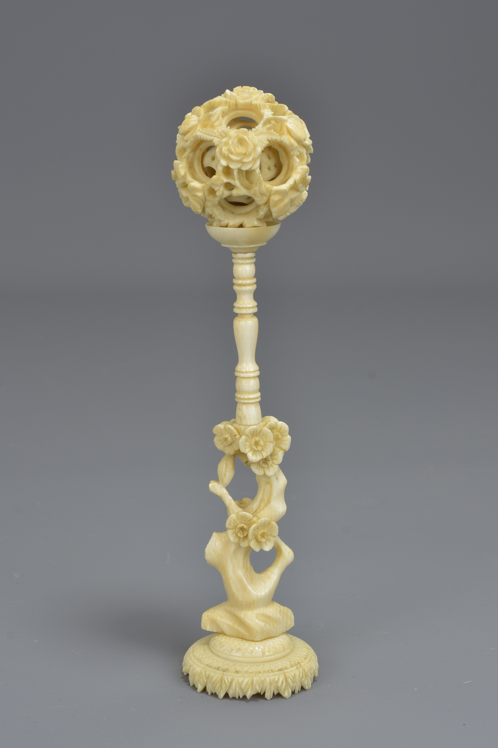 A Chinese 19th century ivory puzzle ball on a carv