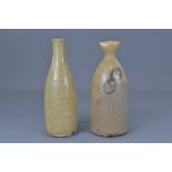 Two Japenese pottery sake bottles, 23 cm tall.