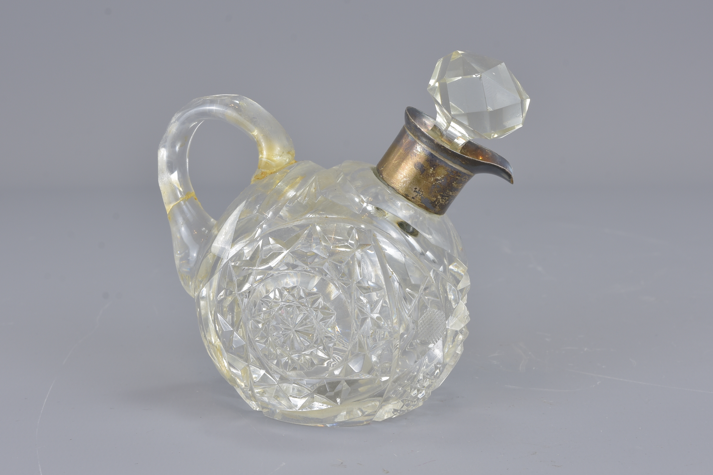 A cut glass vigegar bottle with mounted silver col