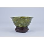 A Chinese Spinach Jade colour Bowenite serpentine Bowl 20th Century with wooden stand.