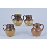 Four Royal Doulton Lamberth stoneware Jugs. (one with crack) 10cm tall, 10cm tall, 10.9cm tall, 11.3