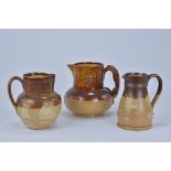 Three Royal Doulton Lamberth Stoneware Jugs. 13.5cm tall, 13.5cm tall, 14.5cm tall (3)