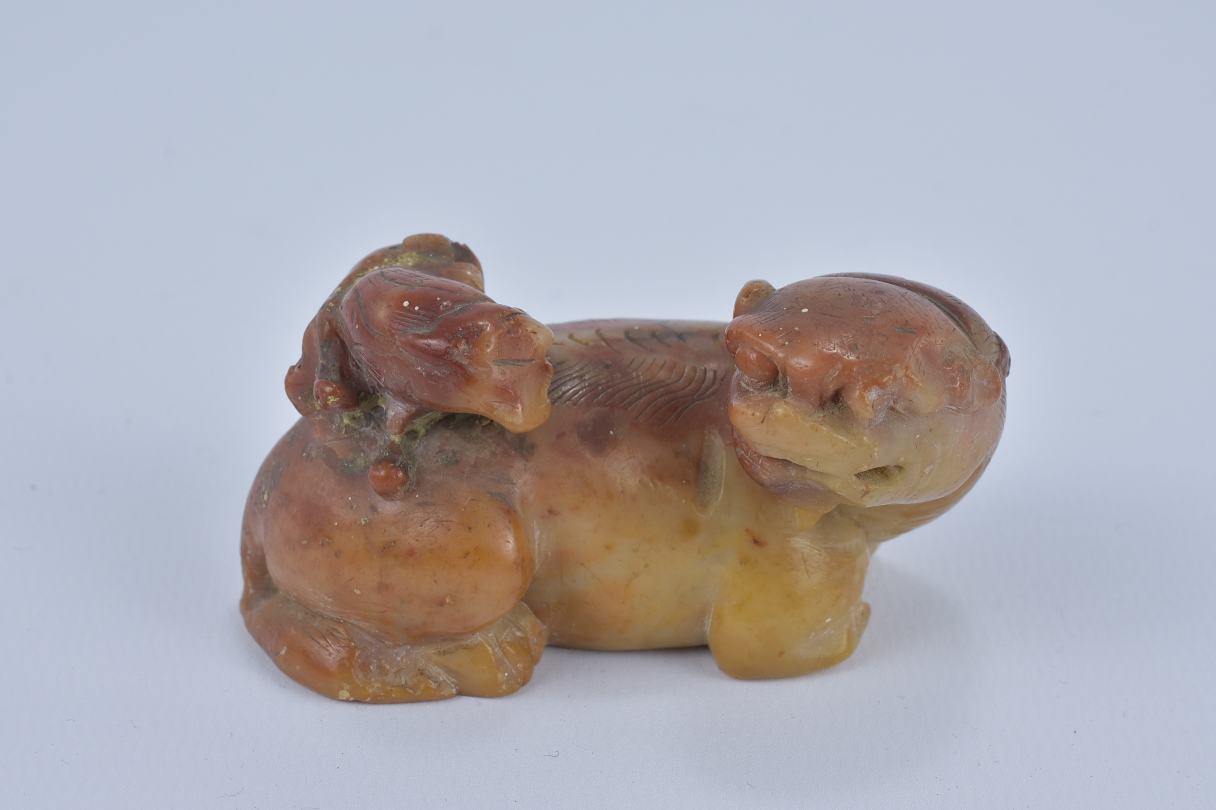 A 19th Century Chinese orange and yellow Soapstone Lion and cub. 7.5cm x 3.5cm