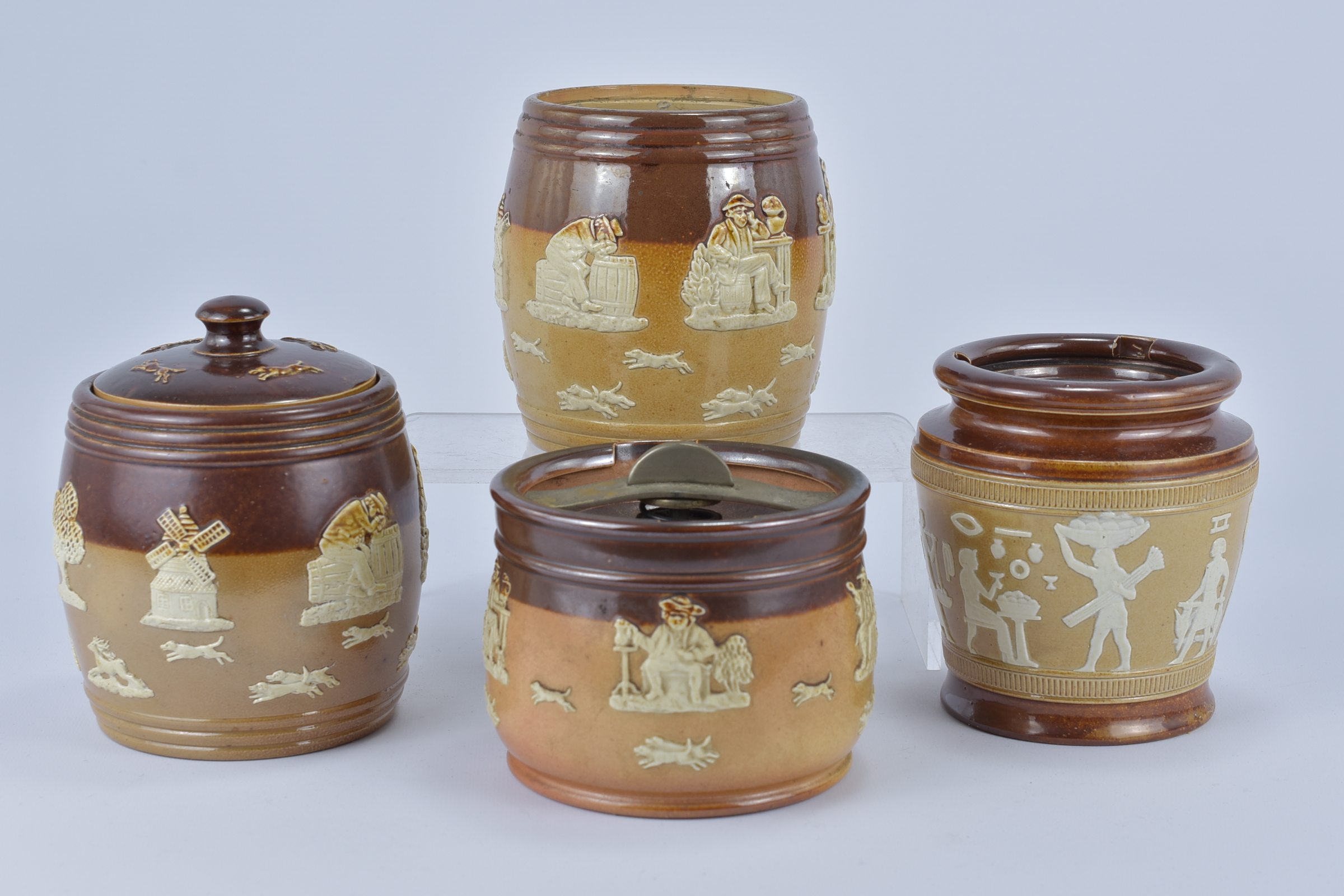 Four Royal Doulton stoneware Tobacco Jars. (two without covers) 10.8cm tall, 12.5cm tall, 12.8cm tal