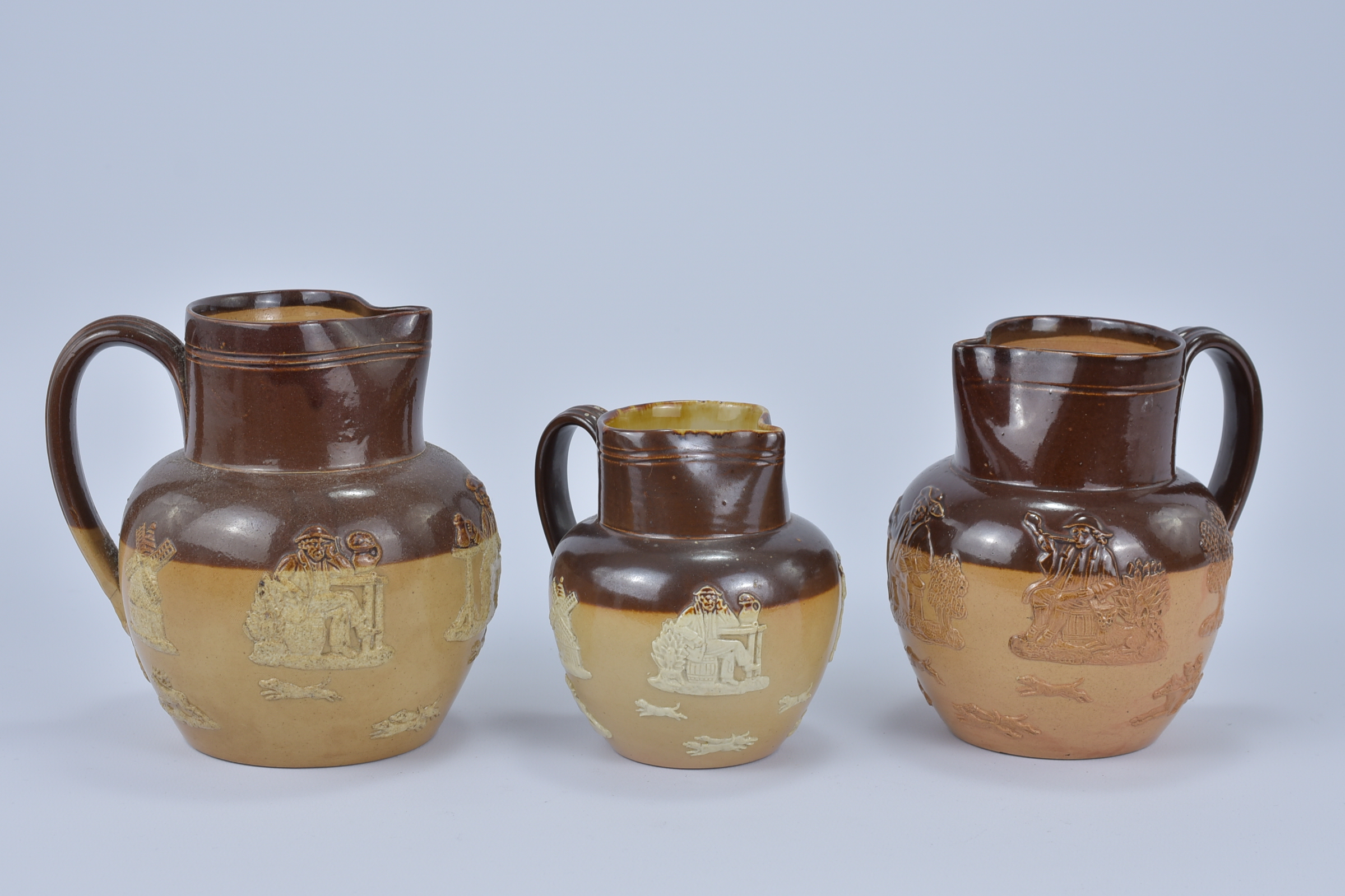 Three Royal Doulton Lamberth Stoneware Jugs. 11.4cm tall, 14cm tall, 14.5cm tall (3)