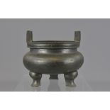 A Chinese 19th century bronze tripod censer with two handles. 12cm