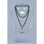 A string of ungraduated Green Jadeite beads in a necklace with Ring Pendant.