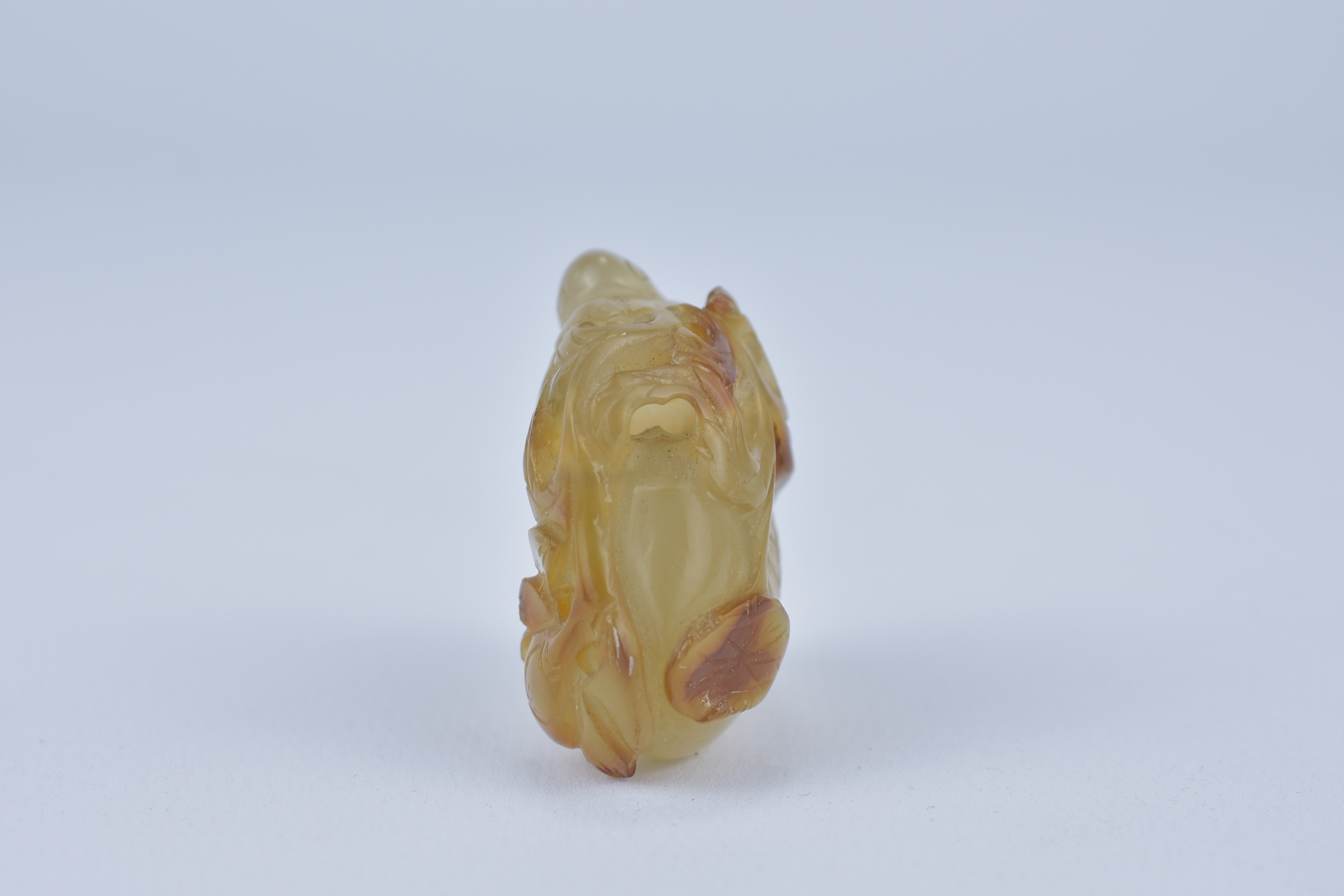 A 19th century Chinese light and dark brown Agate pendant carved as a Duck holding a lotus branch in - Image 3 of 14