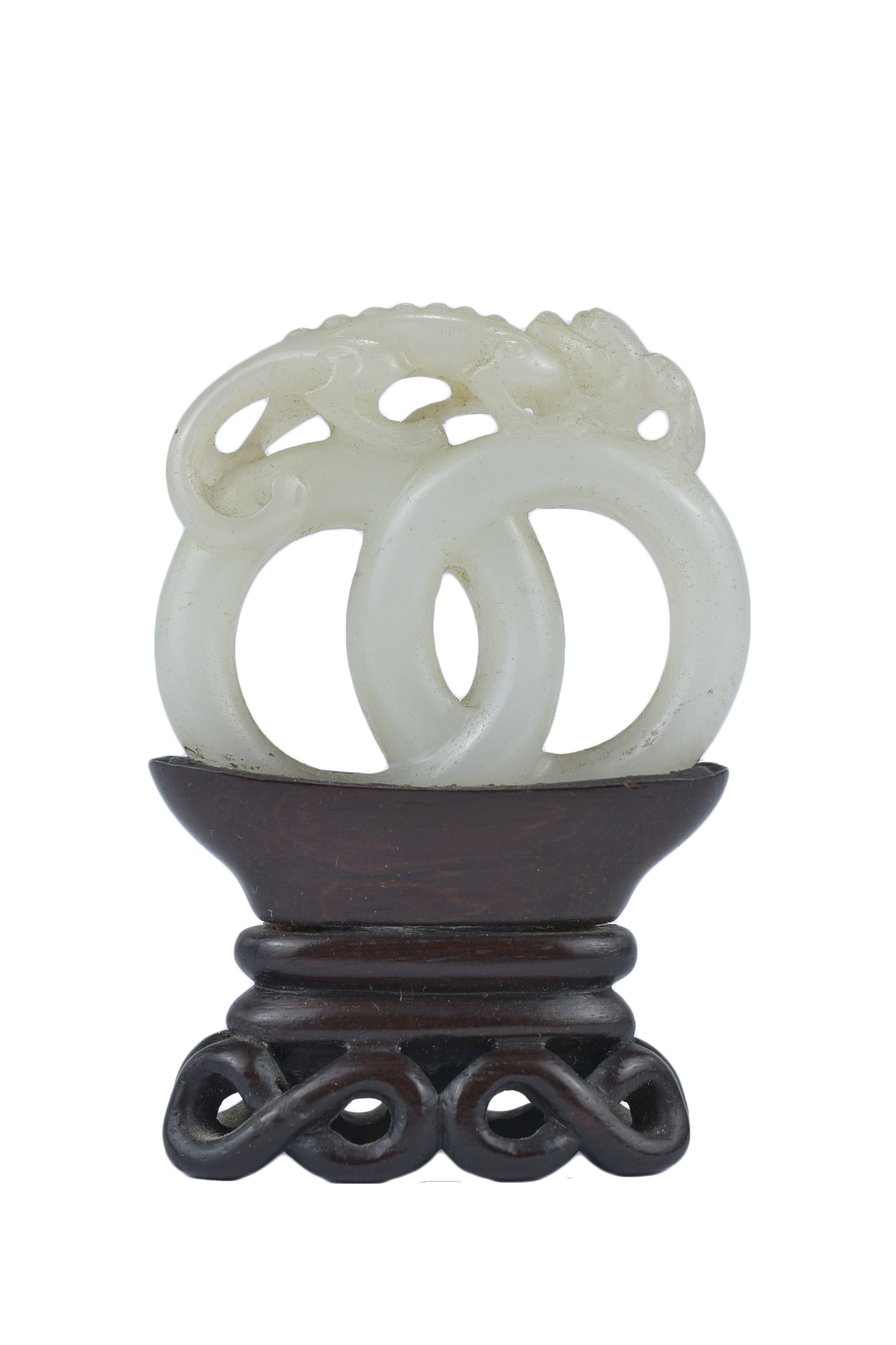 A 19th century Chinese carved White Jade joined rings surmounted by a dragon attached to wooden stan