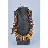 A Large Moroccan Silver, Amber resin and Shells in a string necklace. Largest bead 4cm length