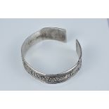 An antique Tibetan hammered Silver cuff bracelet decorated with two lion dogs. 7cm diameter