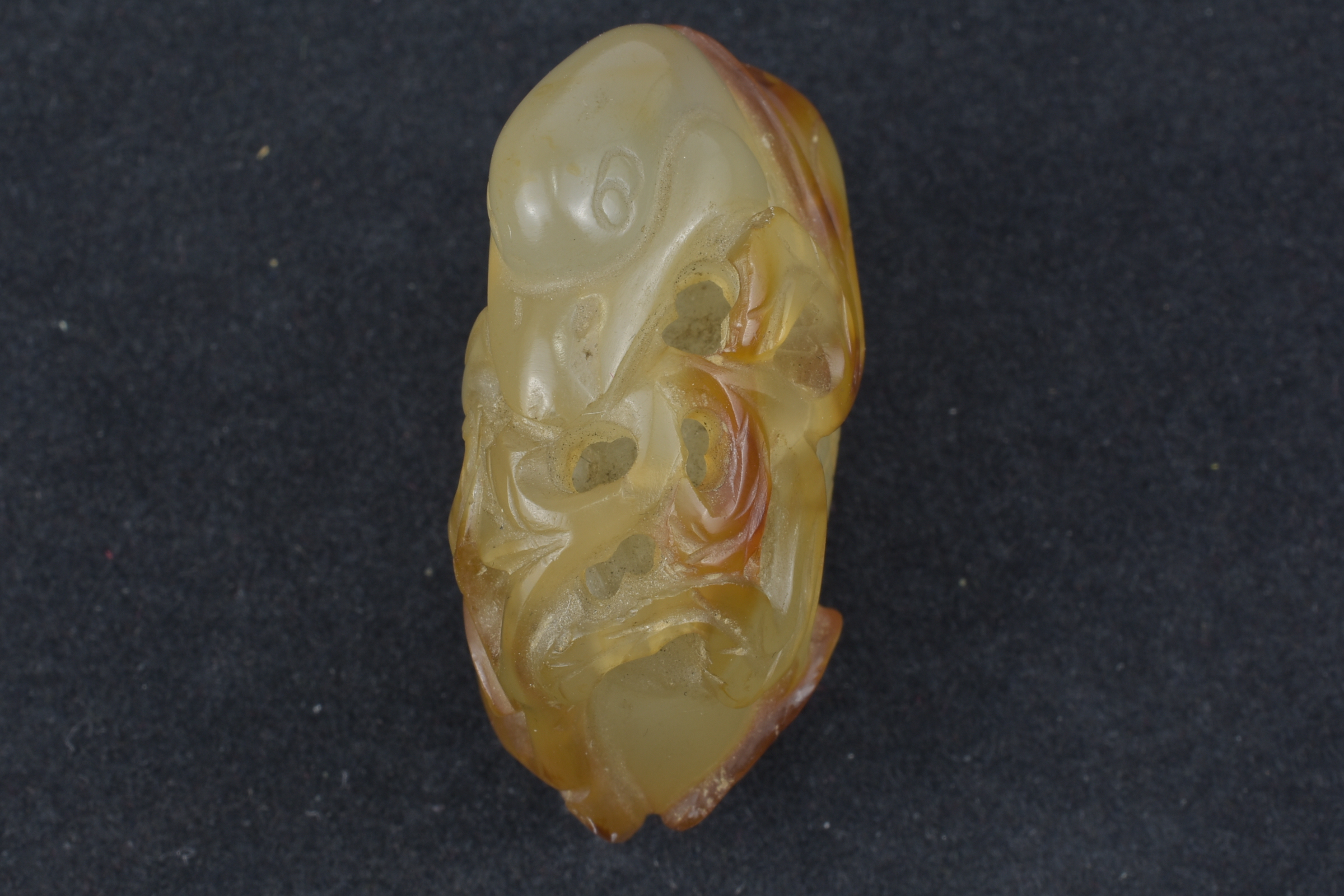 A 19th century Chinese light and dark brown Agate pendant carved as a Duck holding a lotus branch in - Image 14 of 14