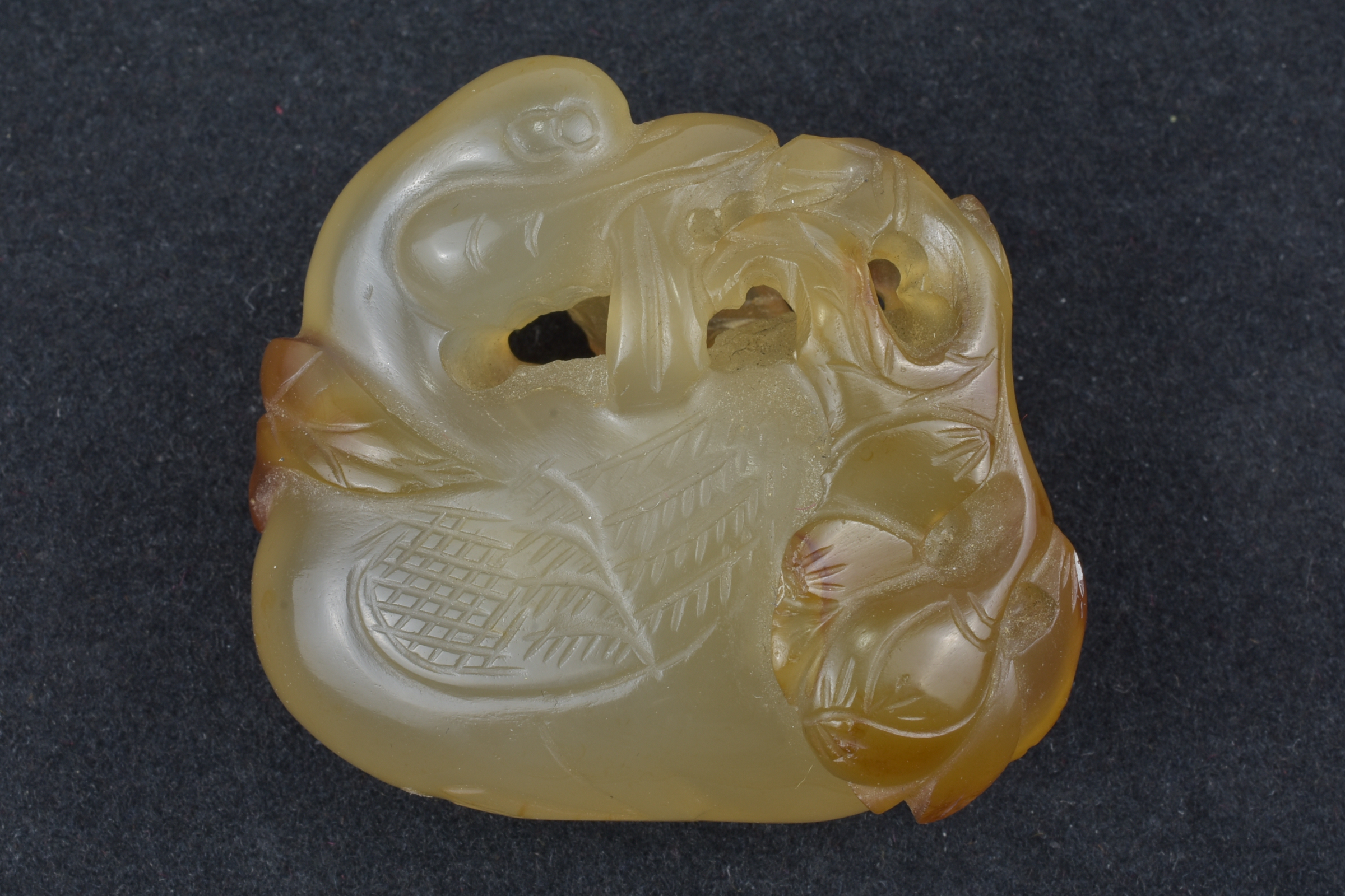 A 19th century Chinese light and dark brown Agate pendant carved as a Duck holding a lotus branch in - Image 12 of 14