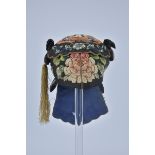 A 19th Century Chinese silk Embroidered Hat with floral design. One tassel missing.