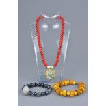 One beaded necklace with glass pendant and two beaded bracelets.