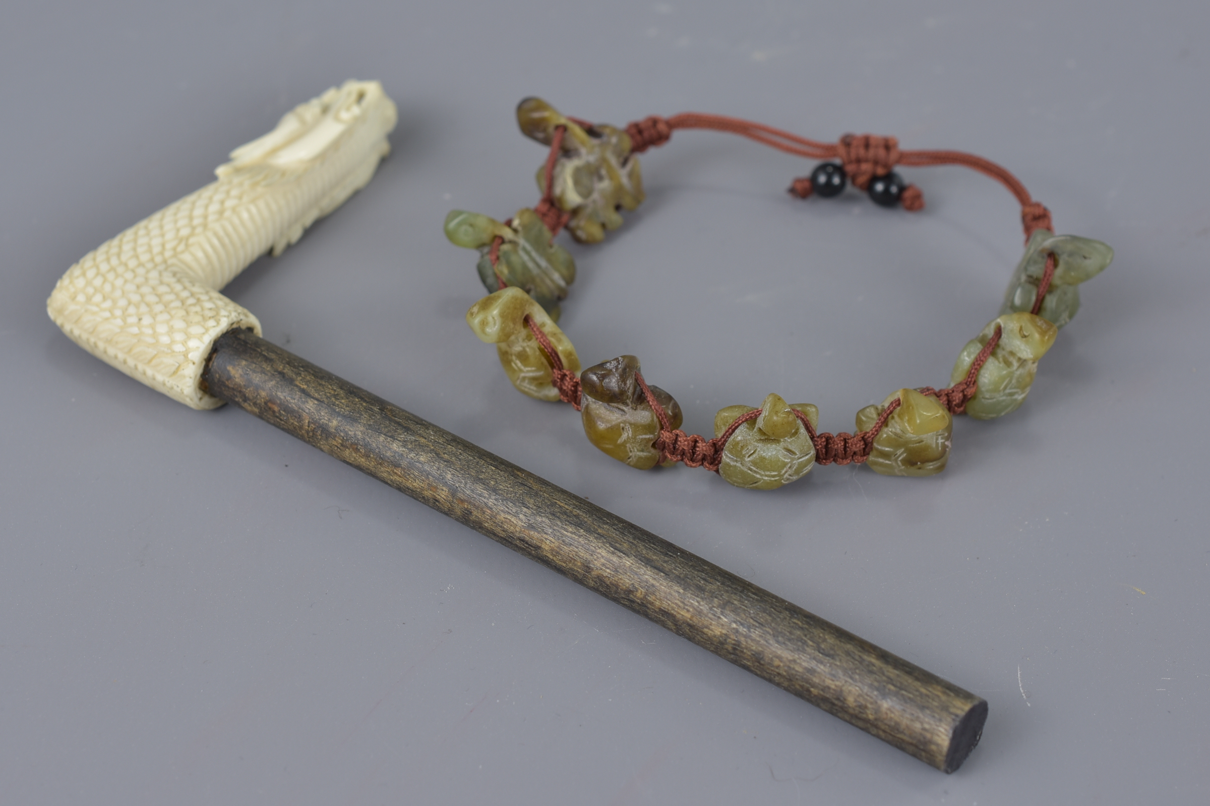 A Chinese Jade turtle string bracelet together with cared ivory parasol handle in the form of a drag