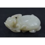 A Chinese white jade carving of a lizard on a peac