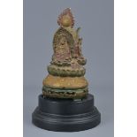 A Tibetan wooden pagoda carved with three Buddhas on display stand. 24cm height