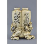 An antique 19th century carved Ivory snuff bottles conjoined on top a lion with bamboo design and in