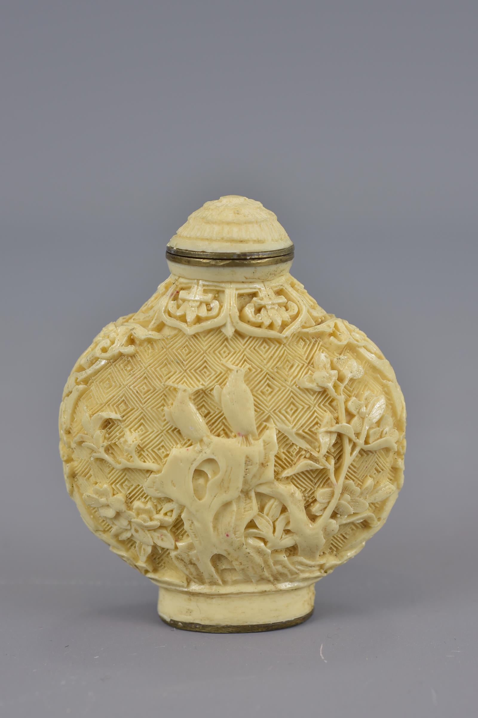 A Chinese carved snuff bottle with stopper and four character mark to base.